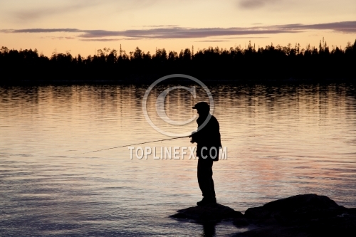 Fisherman silhouette on the beach at colorful sunset
