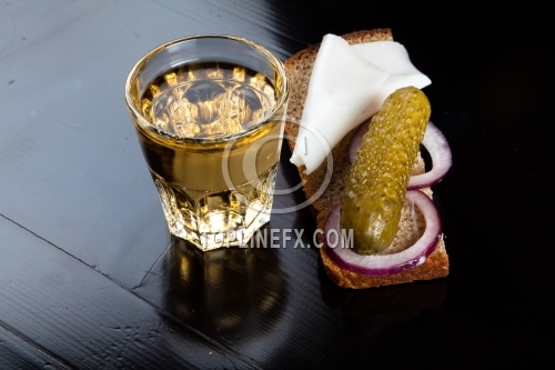 Pepper-brandy in small glass with black bread, pickled, onion and bit of lard